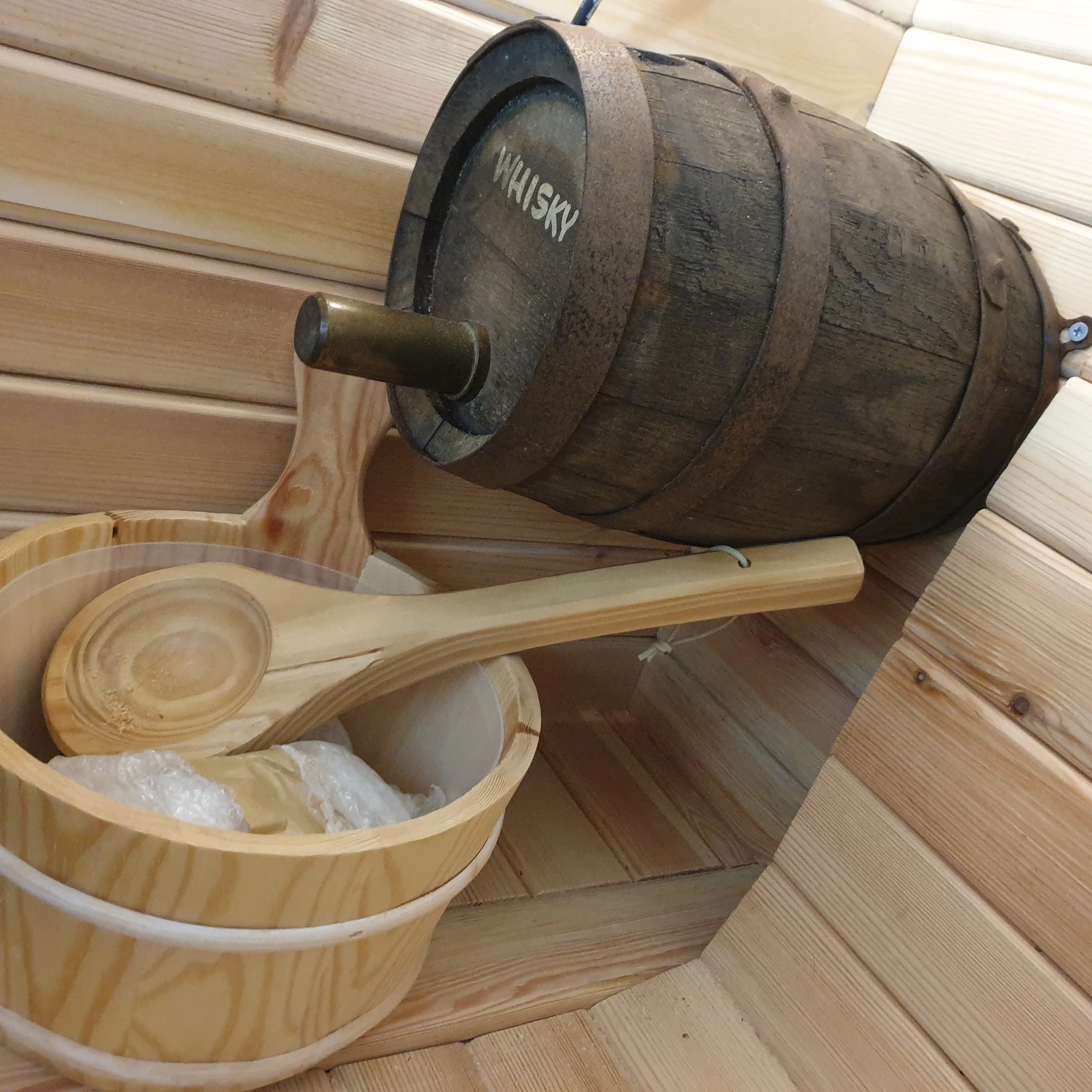 A wooden bucket and ladle for pouring water over the stove stones